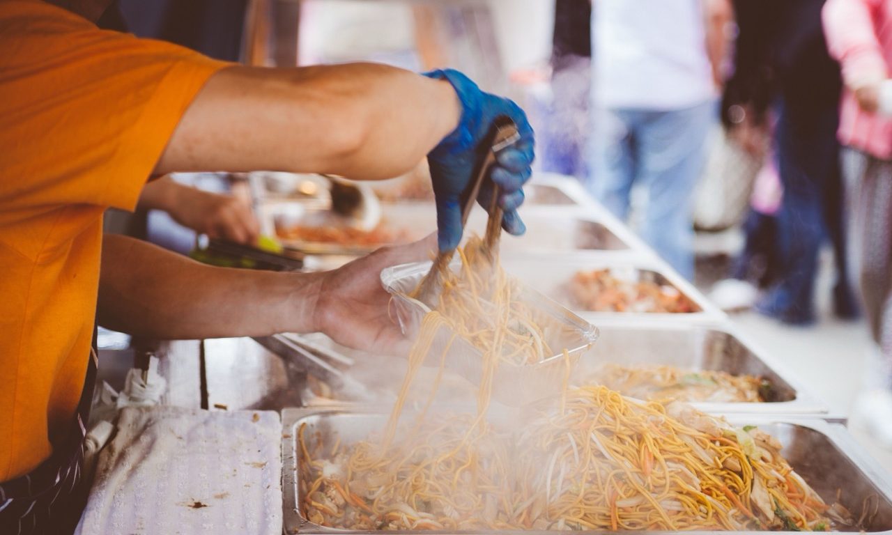 Foodtruck mit geöffnetem Verkaufsfenster bei der Zubereitung von Speisen